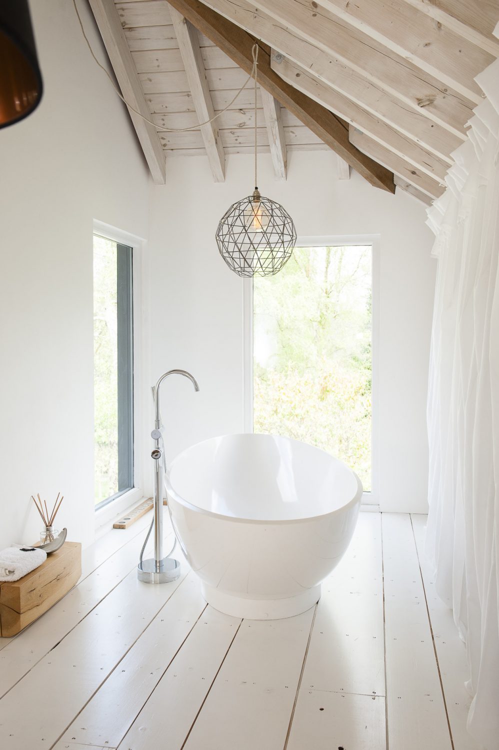 In one corner of the master bedroom a contemporary free-standing bath has been set in a double-aspect alcove overlooking the garden while at the other end is a spacious wet room