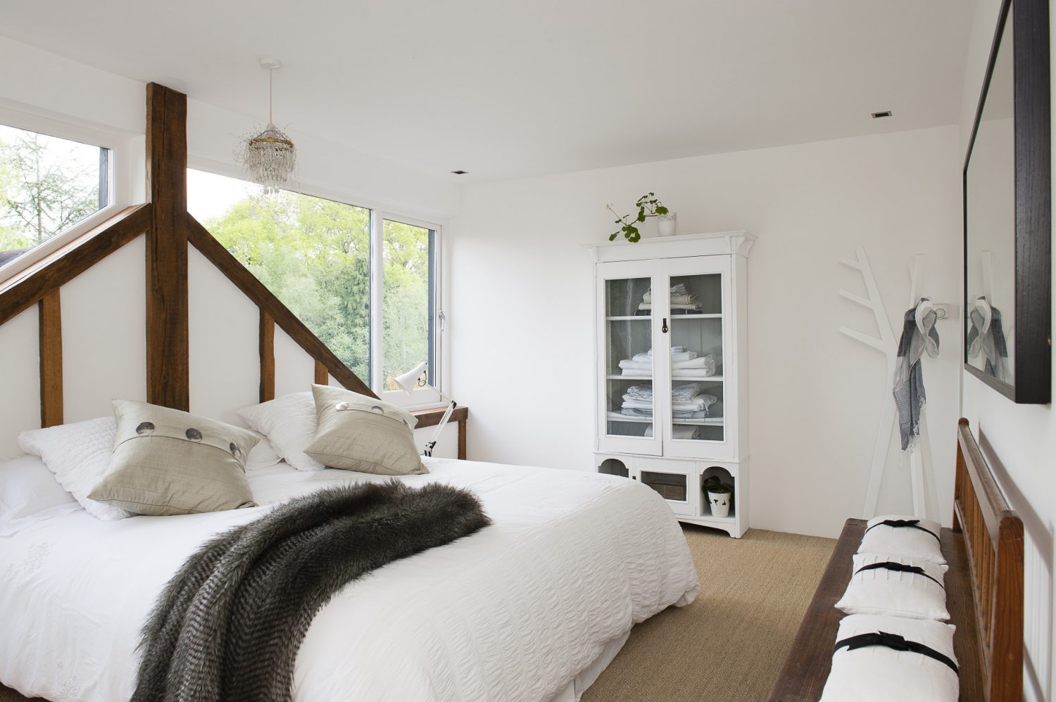 The large window overlooking the treetops is also the headboard for the double bed in one of the guest bedrooms. Sue has cleverly mirrored the view on the opposite wall so one can lie in bed still looking out over the surrounding greenery