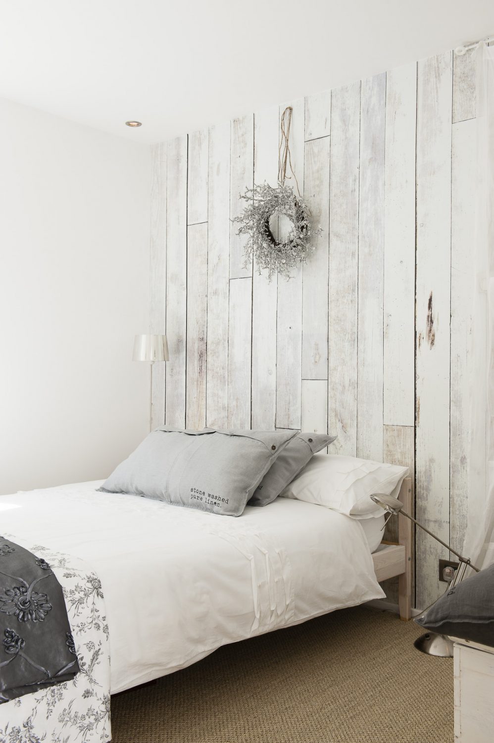 Wood panel effect wallpaper creates a trompe l’oeil on one wall of another guest room
