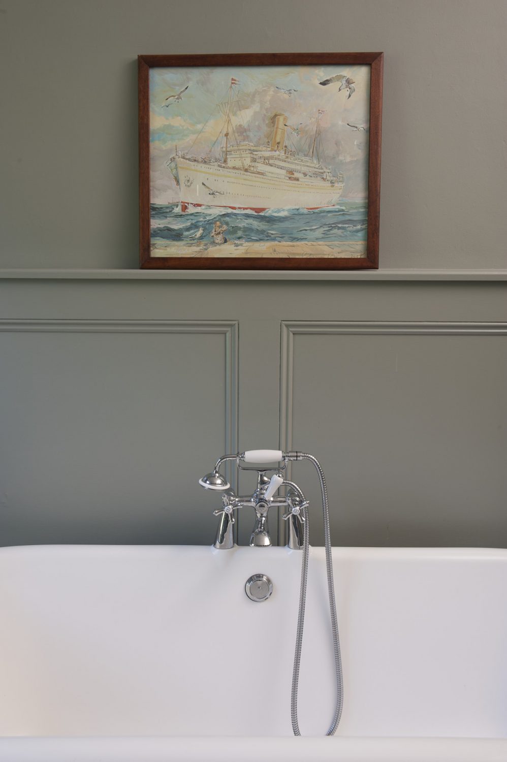 A huge rolltop bath stands against the opposite wall, where Sarah has hung a picture of an ocean liner by Claire Fletcher that she bought for her eldest daughter from Made in Hastings