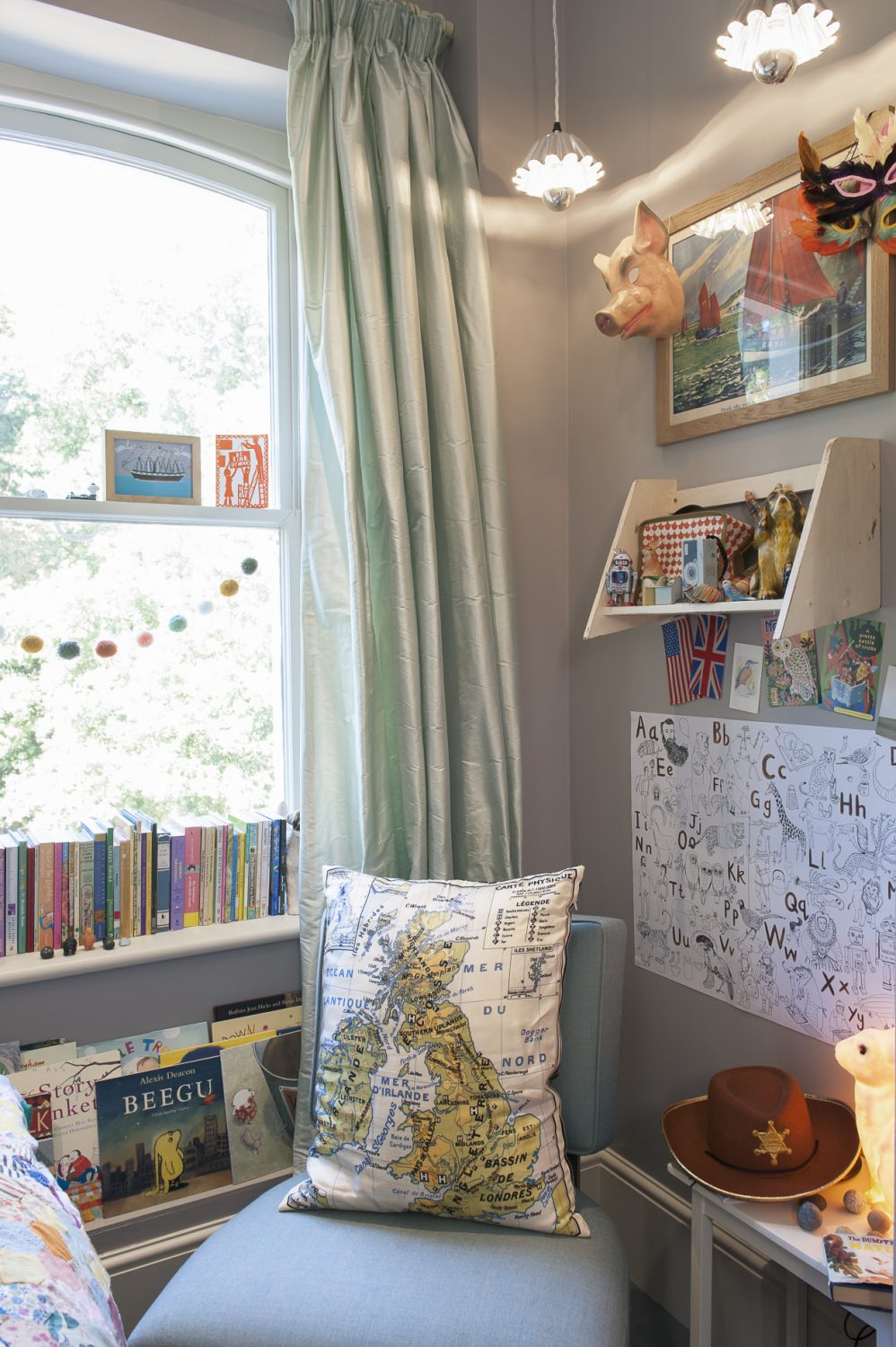 The couple’s children have obviously inherited their parents’ love of books and graphic art, too, because they all give books pride of place. In their youngest daughter’s room there is a little sea green bedroom chair with a silk cushion featuring a map of the British Isles, and a table with a milky white rabbit nightlight to banish the dark.
