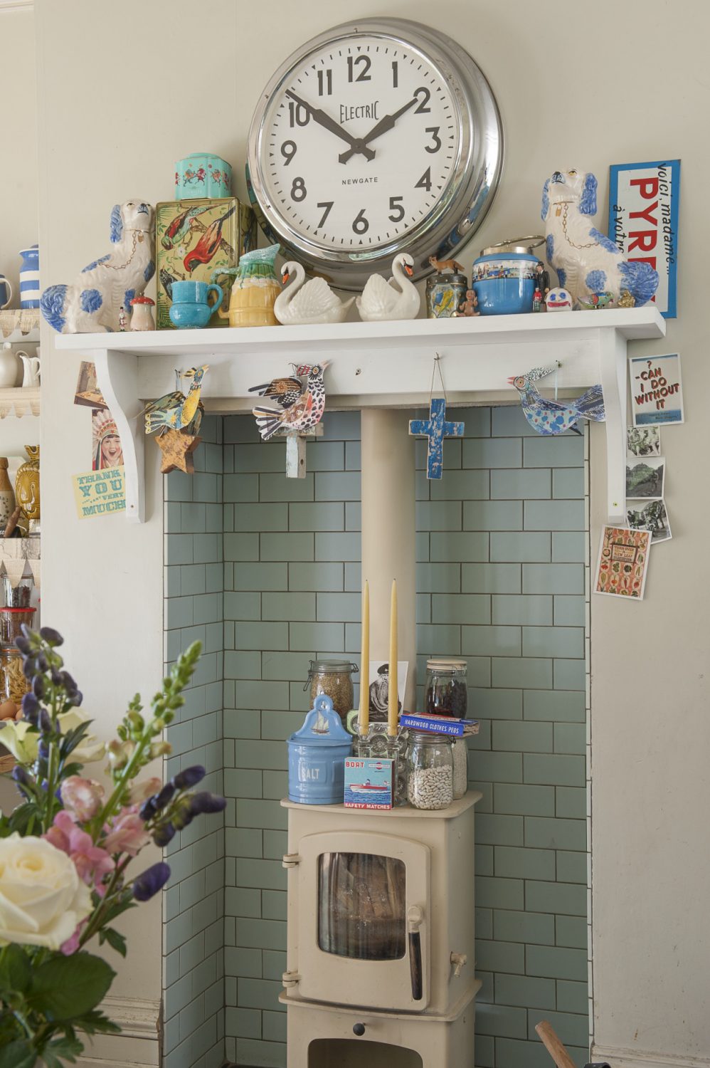 A duck egg blue tiled alcove houses a woodburning stove