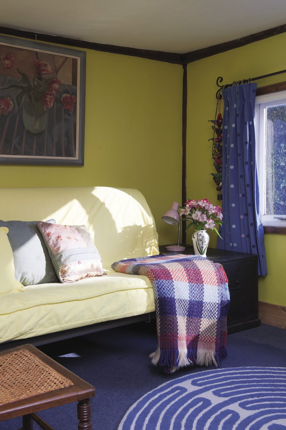 Light pours in through the window in the spare room, bringing its bright yellow walls to life