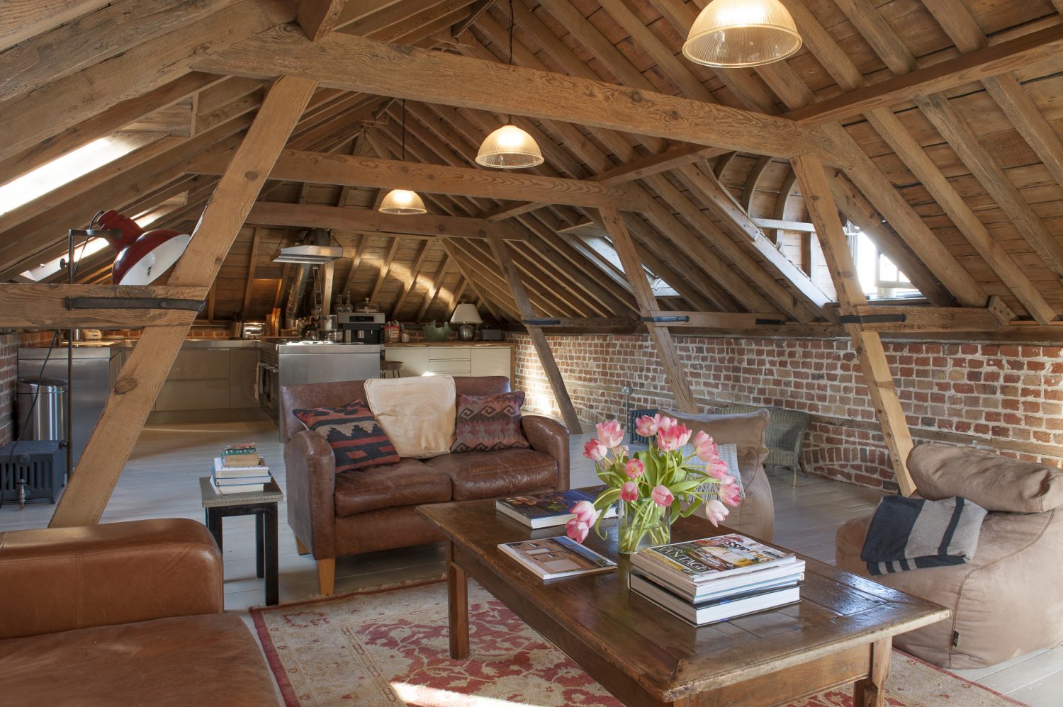 The spectacular space that was once the hay loft boasts superb 230-year-old timbers, every inch now sandblasted and lovingly waxed by hand to a honeyed glow. The only part of the building the couple were unable to save were the floorboards that have now been replaced with irregular-sized painted boards
