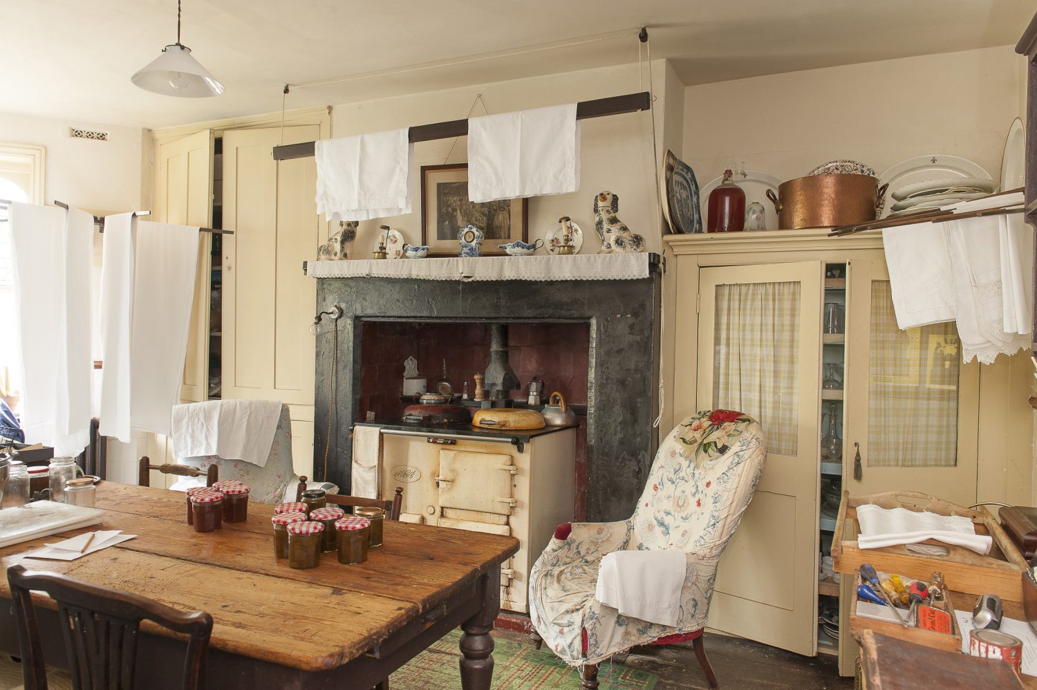 In the large kitchen, ironed cotton sheets hang on wooden hoist and spindle airers