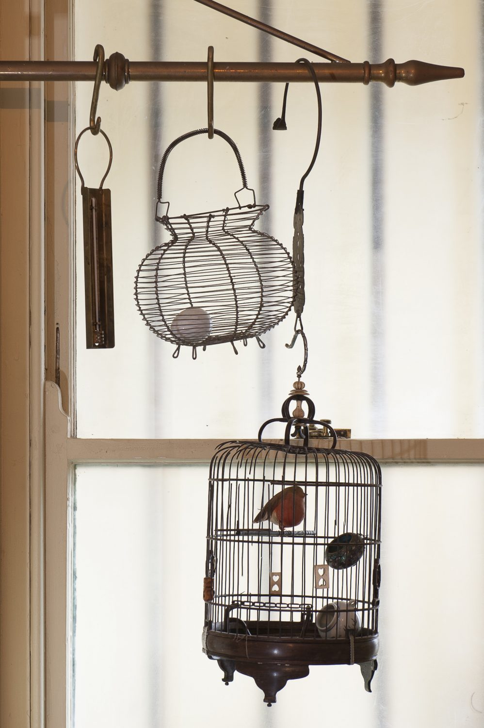 A decorative birdcage hangs in the kitchen