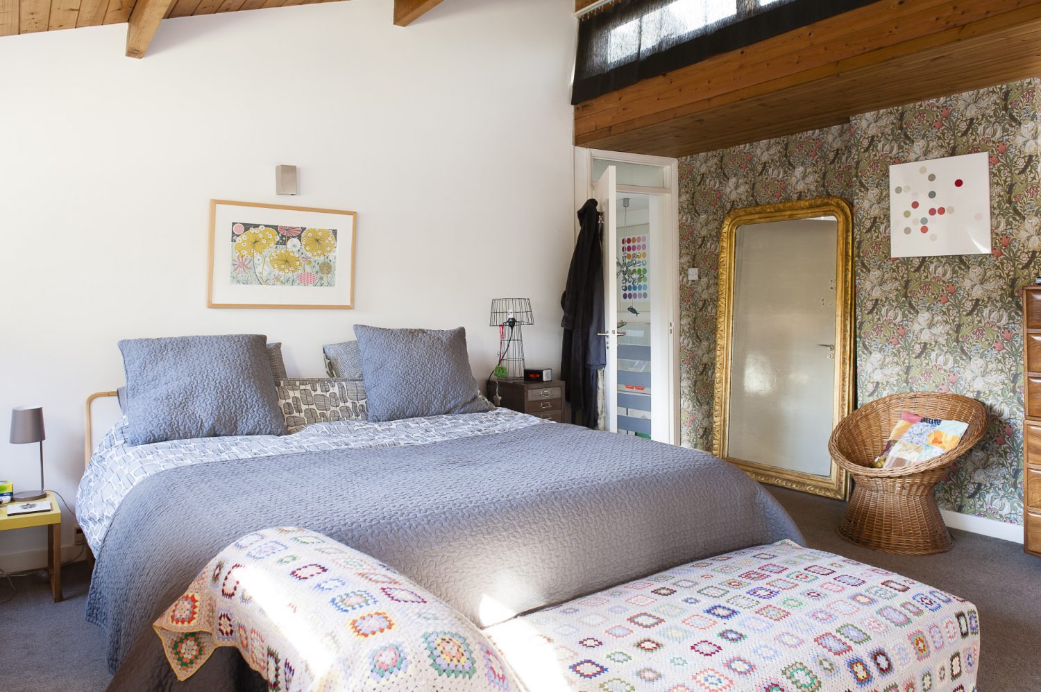 The master bedroom was once virtually all pine, three walls and soaring pitched ceiling. Sam covered one wall in a William Morris print, leaving the ceiling bare