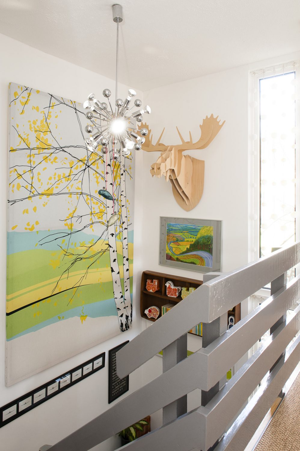 Halfway up the stairs hangs a truly vast canvas of silver birches from Skandium and a Banksy limited edition