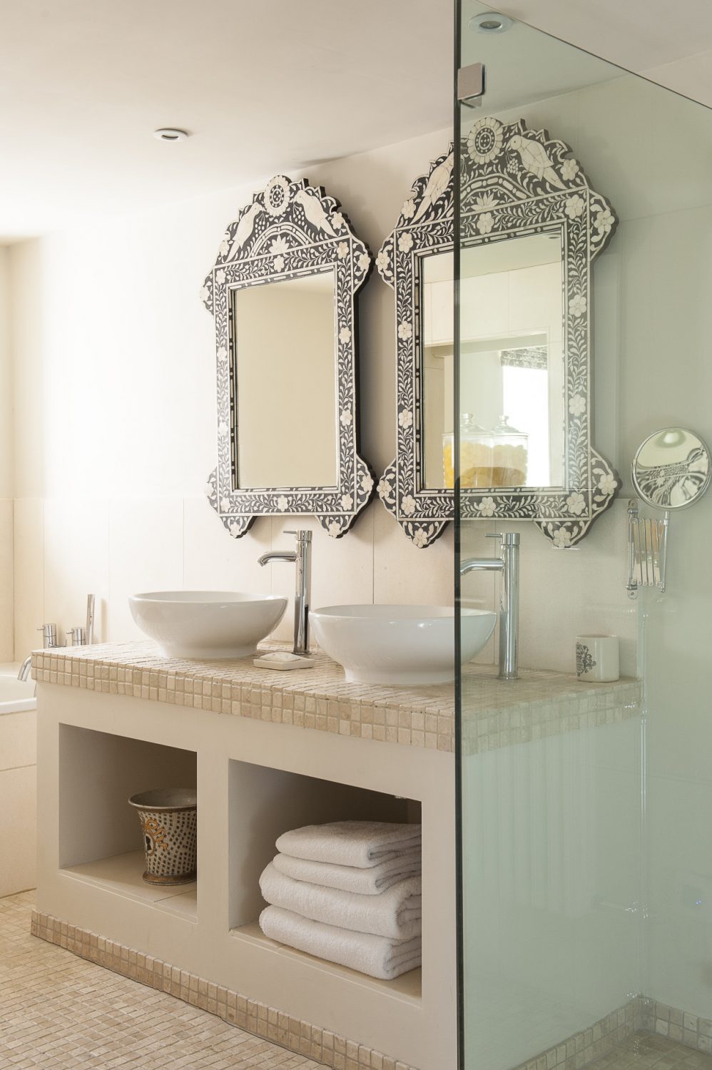 A pair of Moorish mirrors are a striking feature of Keynes’s limestone en suite, complete with a deep bath and glass-walled wet-room shower
