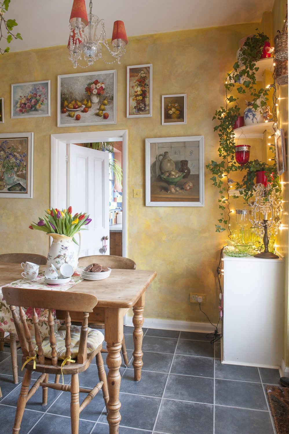 The yellow breakfast room is covered in still life pictures and cascades of ivy