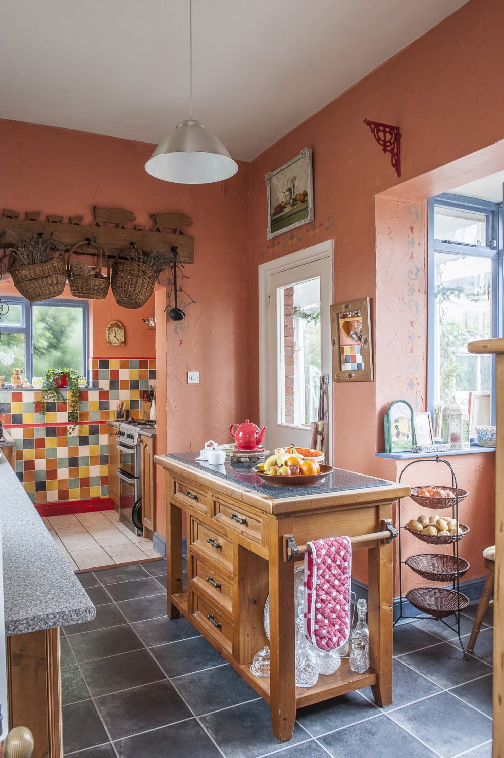 The kitchen is painted and tiled in a Spanish palette of rich terracotta and sunshine yellow