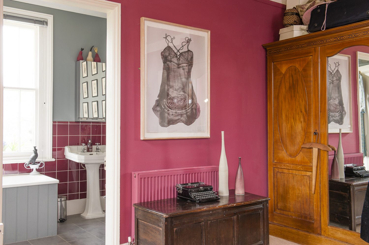 The spare bedroom is painted a juicy raspberry red, the bed covered with a boiled felt throw