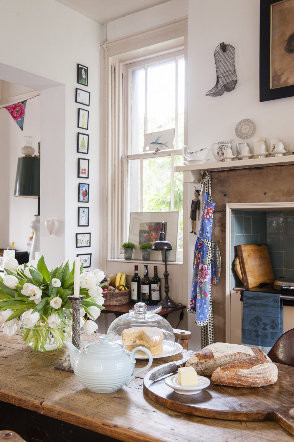 Freshly baked bread and cake make a welcoming sight on the kitchen table. Ceramics by Kate Schuricht, Sue Binns, Andre Wicks and Stuart Houghton line the mantelpiece