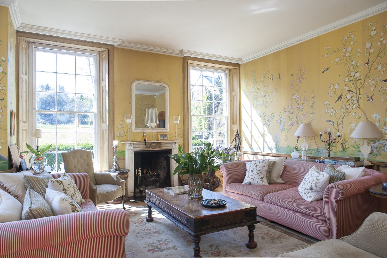 The drawing room, with its open fire and huge sash windows, overlooks the lawn and mature gardens. Christel has had the Conran sofas for many years, while the Indian ‘elephant table’ belonged to Lord Cowdrey and came from Bangalore. Josef Holst painted the Chinese-style murals