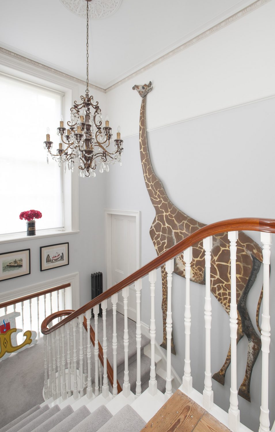 A full sized cut-out of a giraffe reaches virtually from the ground to first floor