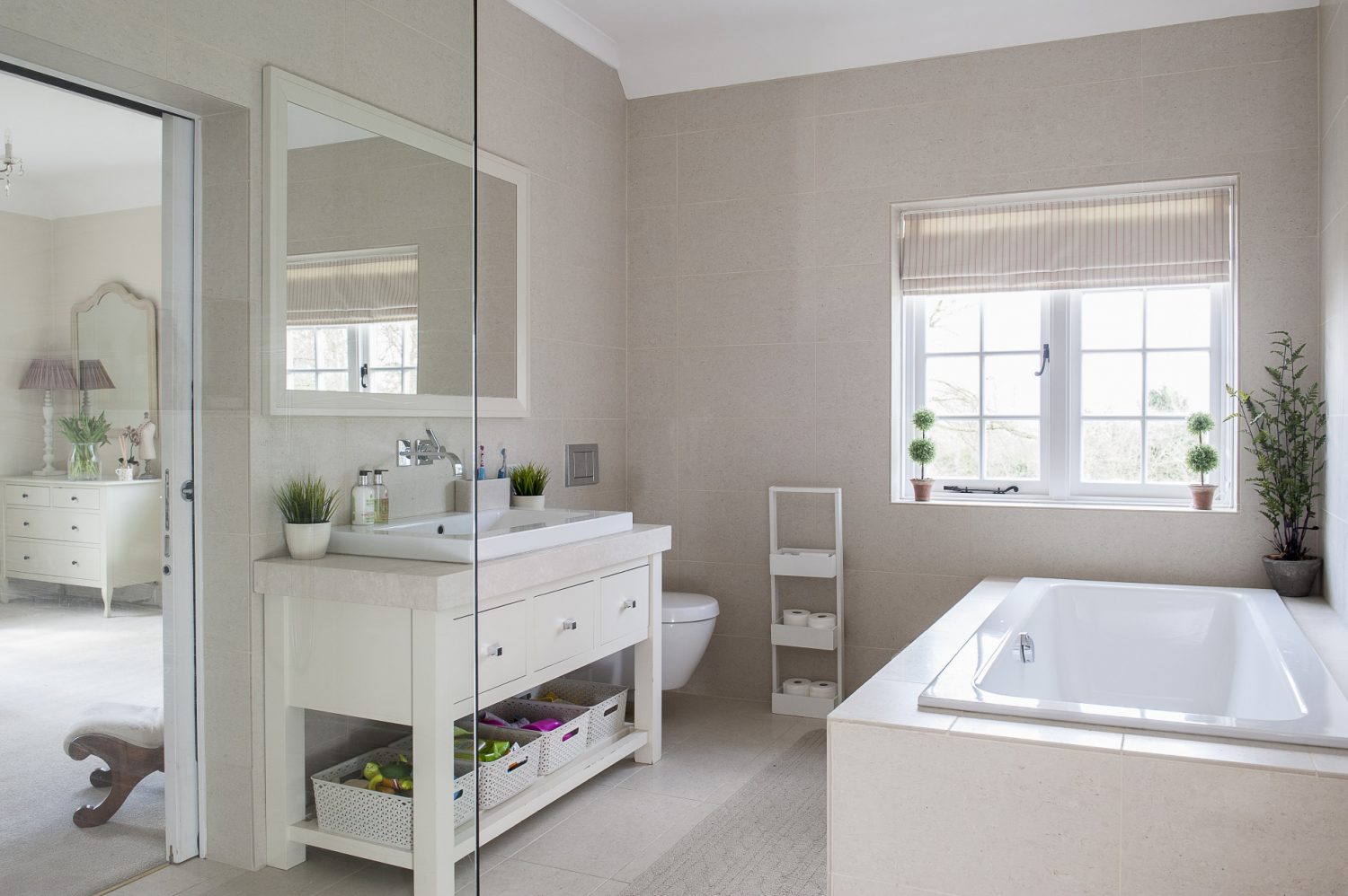 The children’s Jack & Jill bathroom has sliding doors to leave maximum space for washing. Pale travertine tiles cover the floor and walls and the room was tanked to cope with splashes from the huge bath and walk-in shower