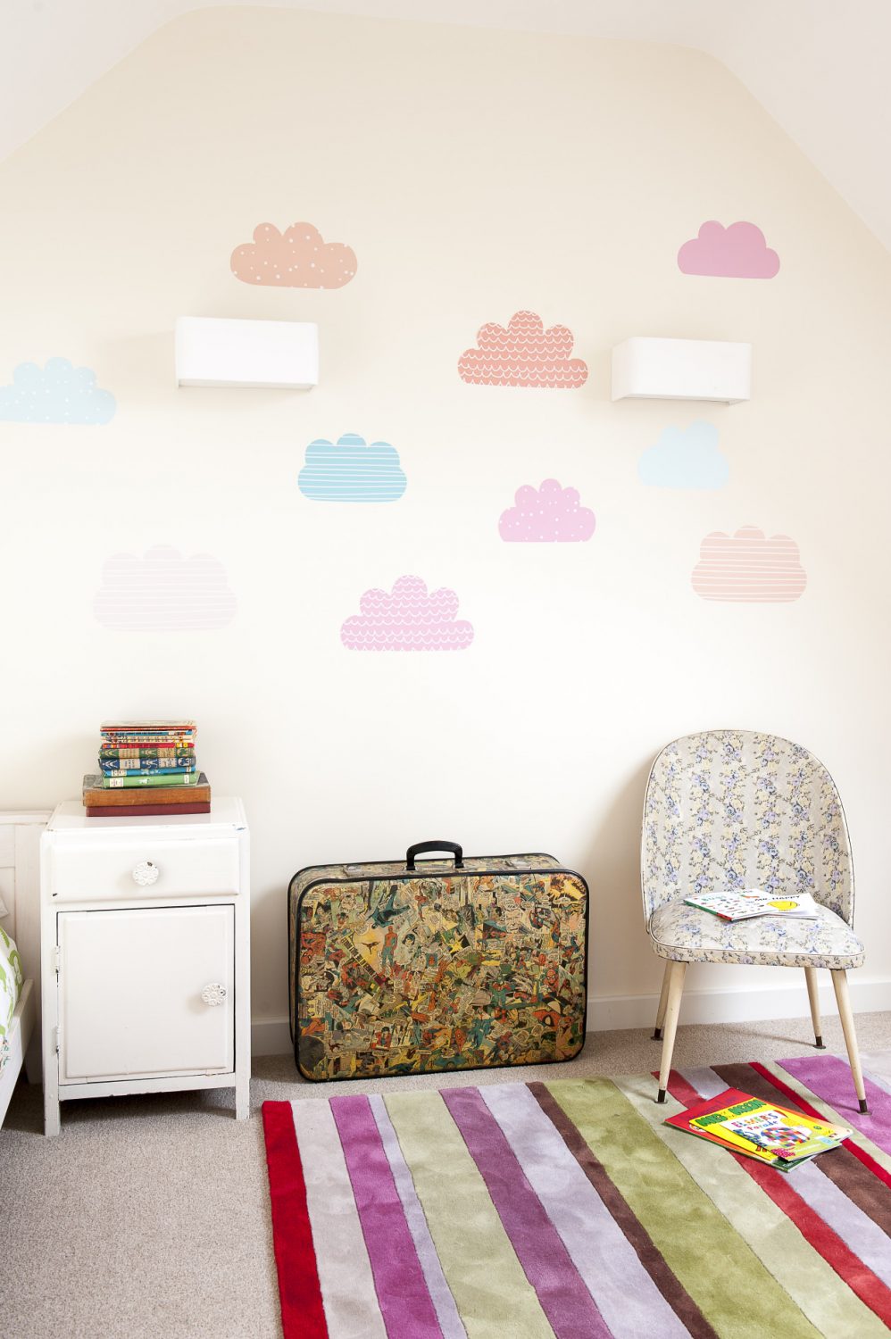 Pastel paper clouds float across one wall of the children’s guest room at the top of the house