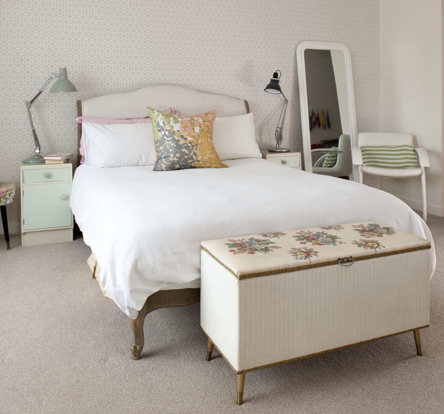 The master bedroom adheres to a palette of delicate whites and pastels, the trellis wallpaper by Harlequin. Each side of the Loaf bed are matching 60s cabinets on which stand two Anglepoises – one 60s and the other contemporary. Beside the bed stands an elegant, 60s steel-framed, white leather chair