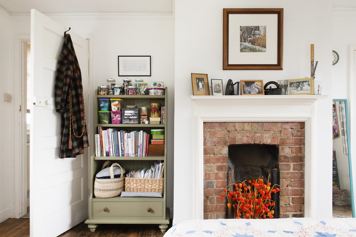 A shelving unit painted in muted, vintage green is used to keep Claire’s collection of buttons, ribbon and other sewing items tidy. Claire made the patchwork quilt herself and has filled another unused fireplace with Chinese Lanterns to add some colour and a sense of warmth to the room