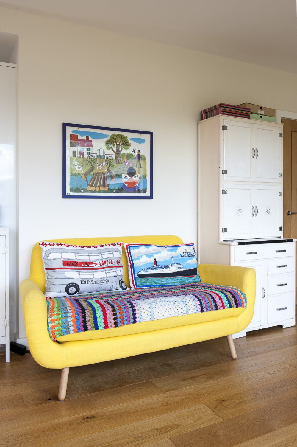 The pretty 60s-style sofa is from Made.com and above it hangs a 1960s French schoolroom poster
