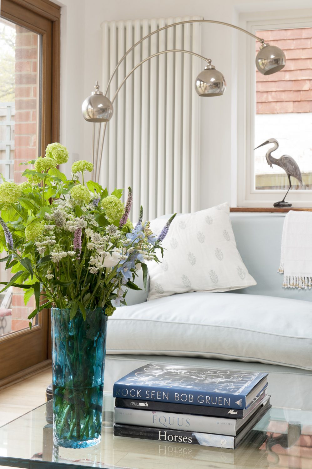 Retro lamps contrast with a vase of pretty cottage garden flowers and an elegant heron sculpture
