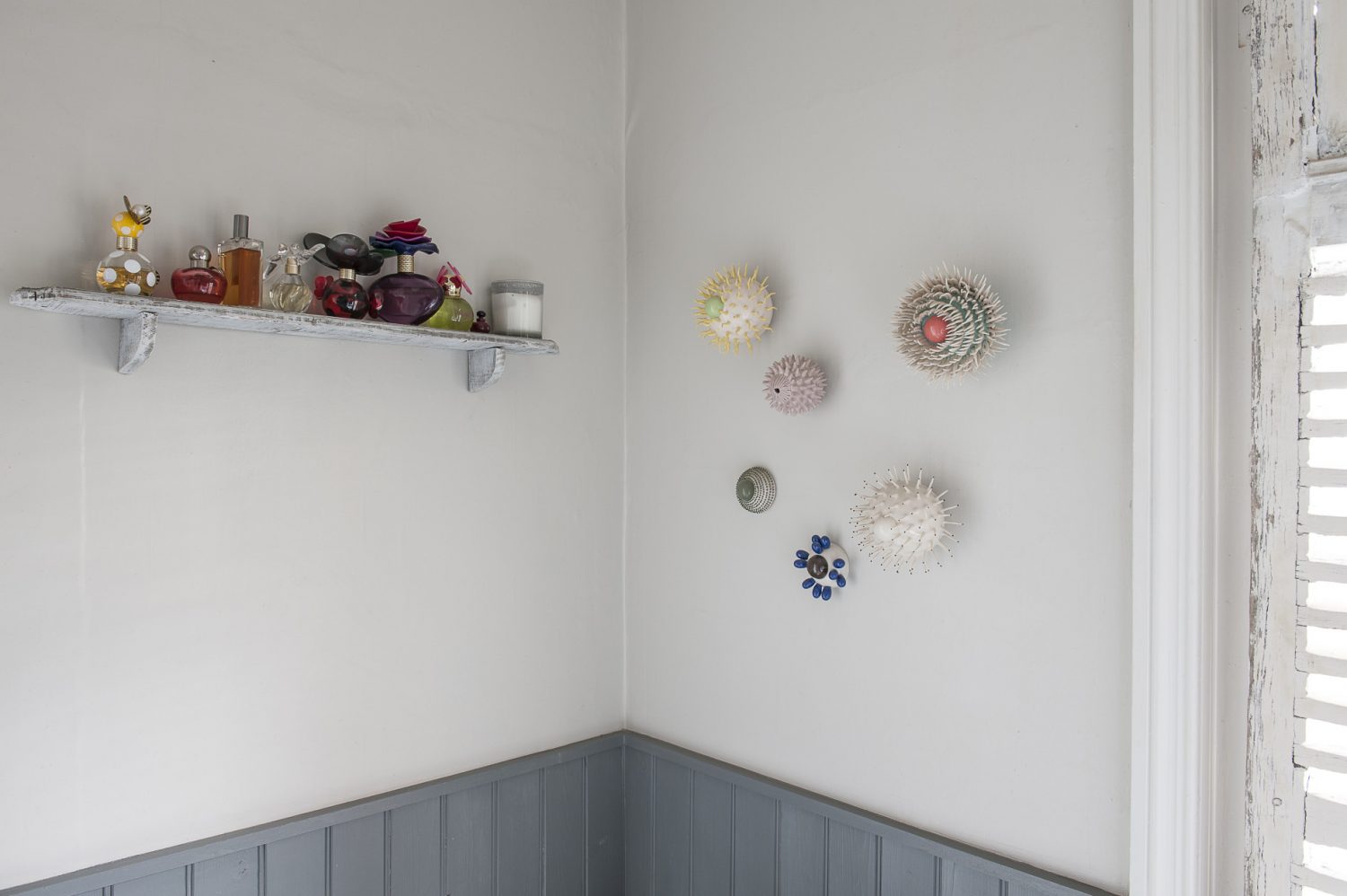 A grouping of spiky ceramic sculptures, reminiscent of sea anemones, from Myung Nam An are mounted on one wall