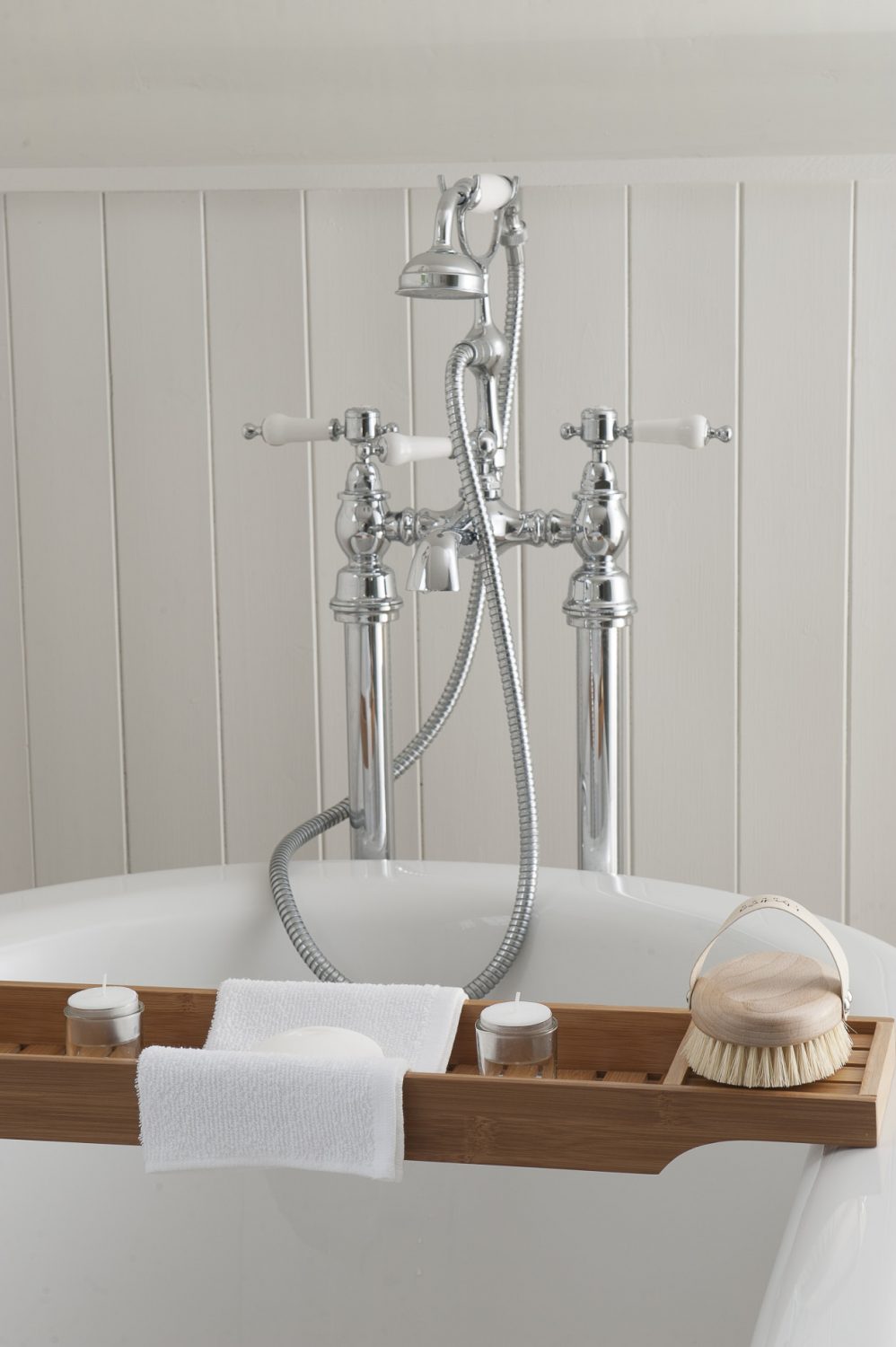 Victorian-style taps adorn the end of a freestanding, roll-top bath