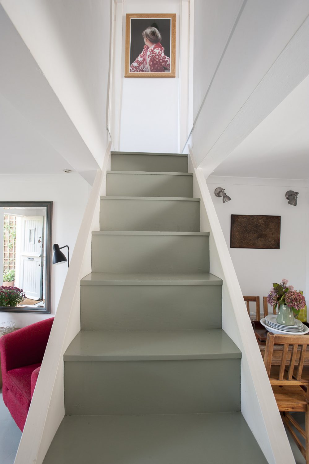 The staircase in the centre of the living room leads to the two upstairs bedrooms