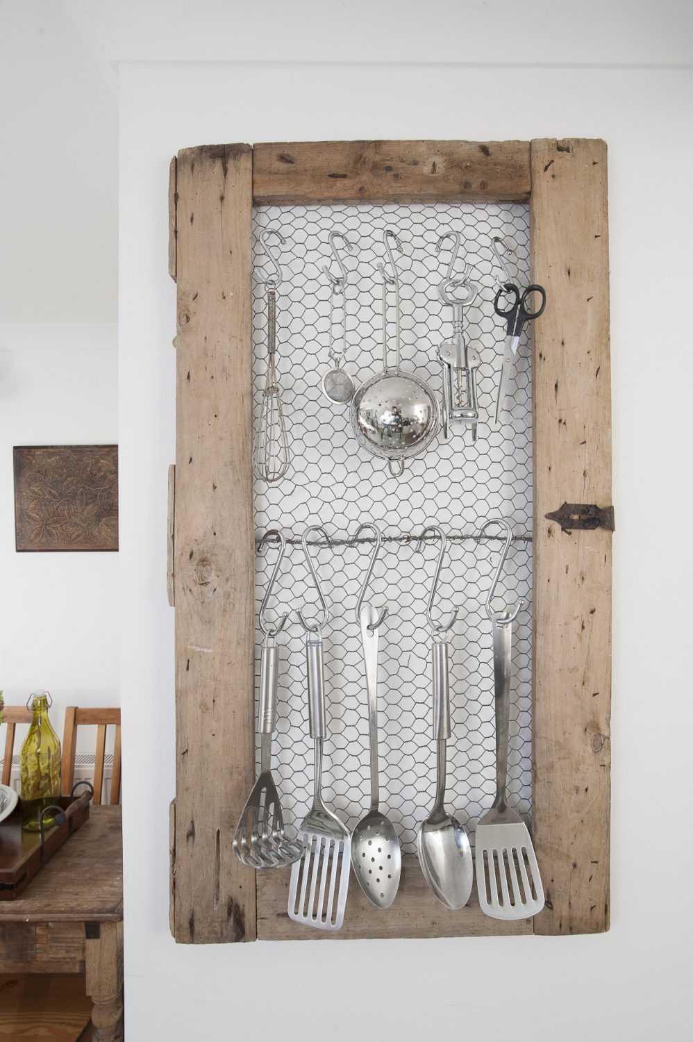 On the wall is a clever French find that has allowed Linda to indulge in her passion of displaying every-day objects: an old pair of cupboard doors backed with chicken wire