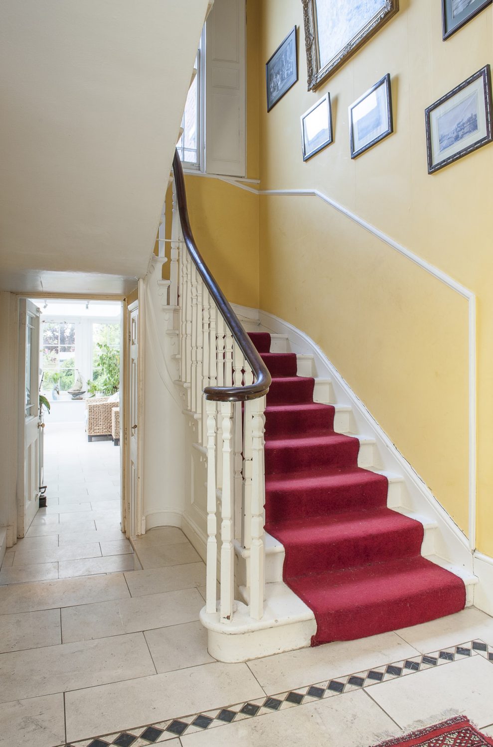 The sunny yellow of the hallway continues up to the soaring ceiling of the landing