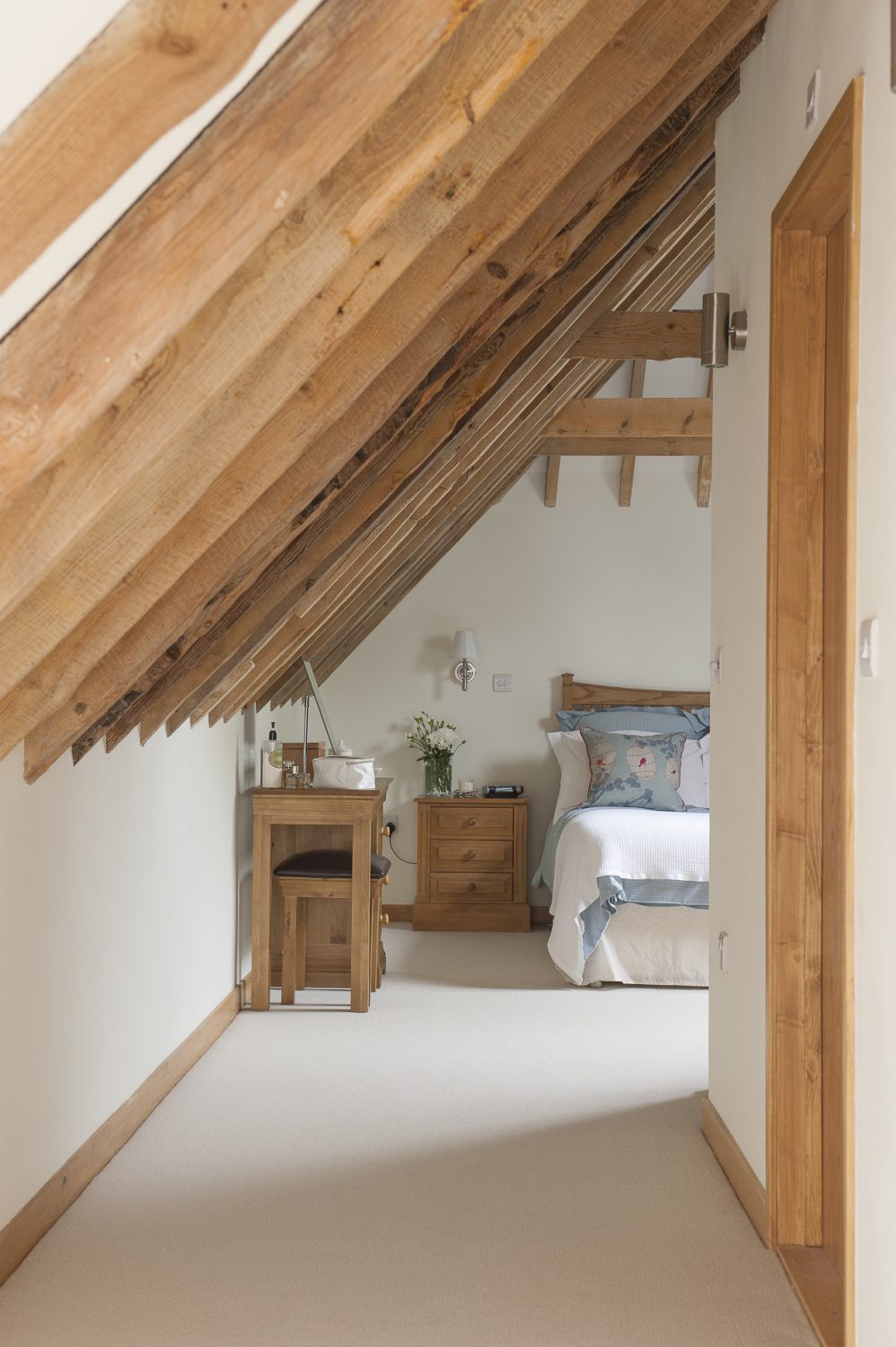 Above, the master bedroom and en suite nestles in the eaves of the building