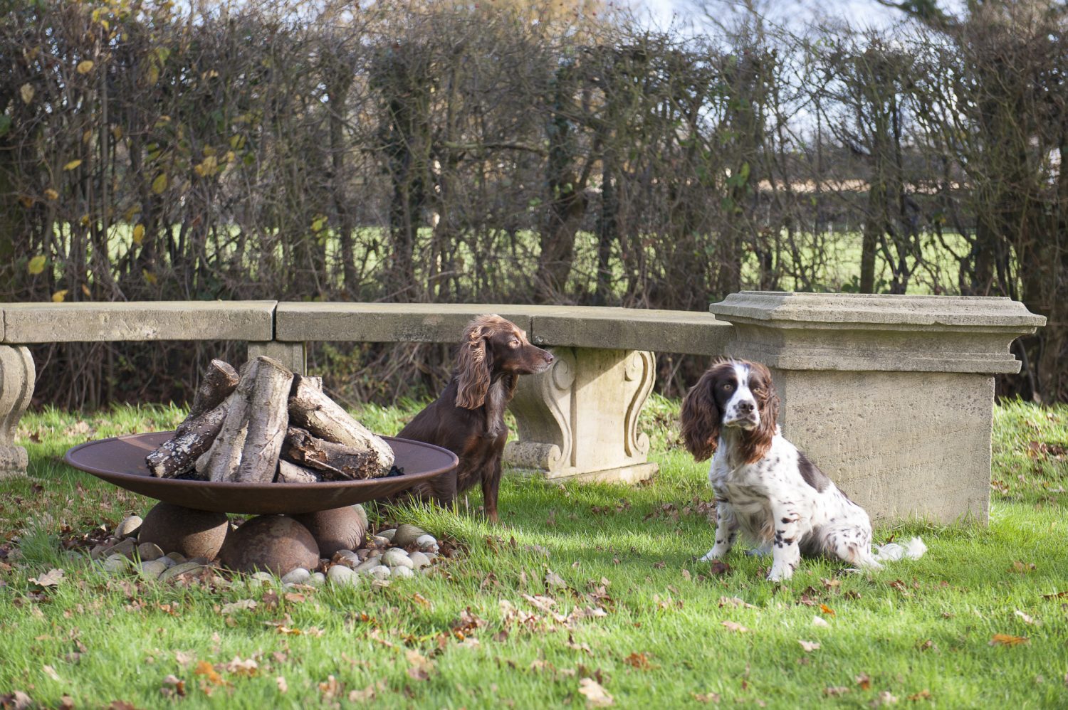 A seating area in the garden with a fire-pit made by Cranbrook Iron