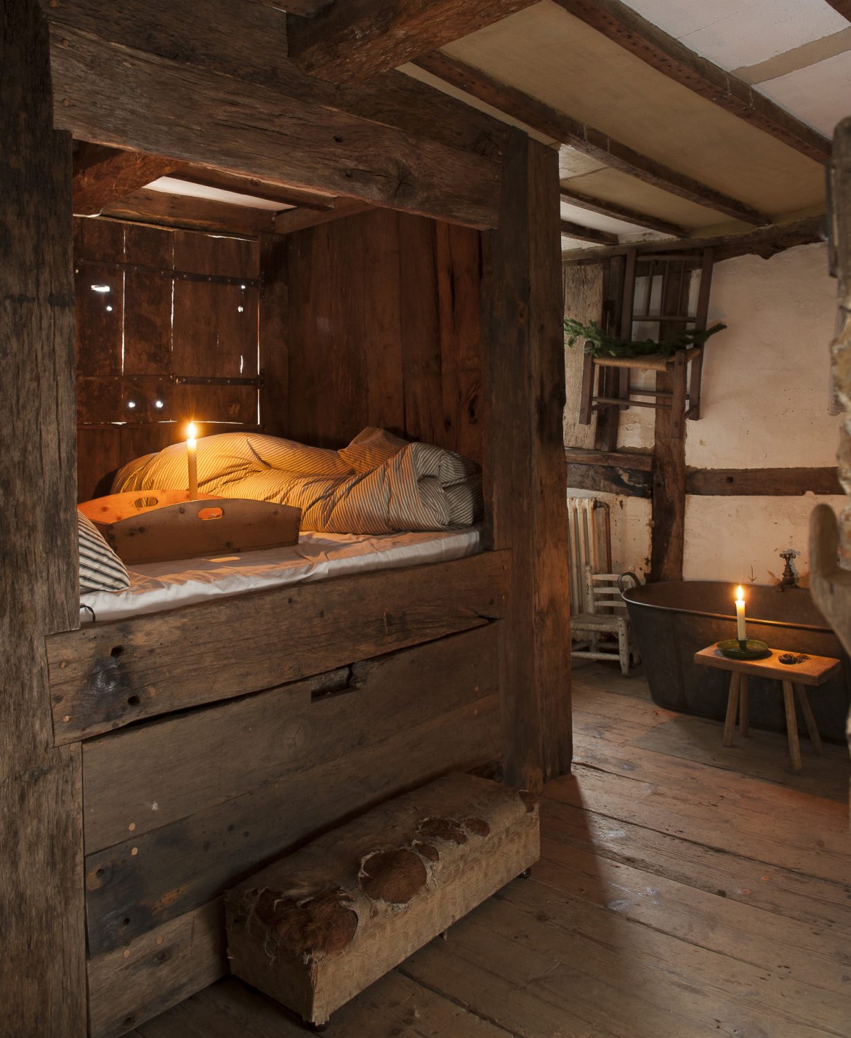 The main bedroom, with its Tudor ‘en suite’ is home to a raised bed enclosed by wood panelling and shutters