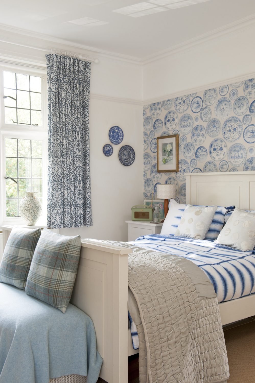 At the end of the landing is a really pretty guest room which features an Andrew Martin willow pattern plate design wallpaper, colours from which have been picked up in curtains, throws and cushions