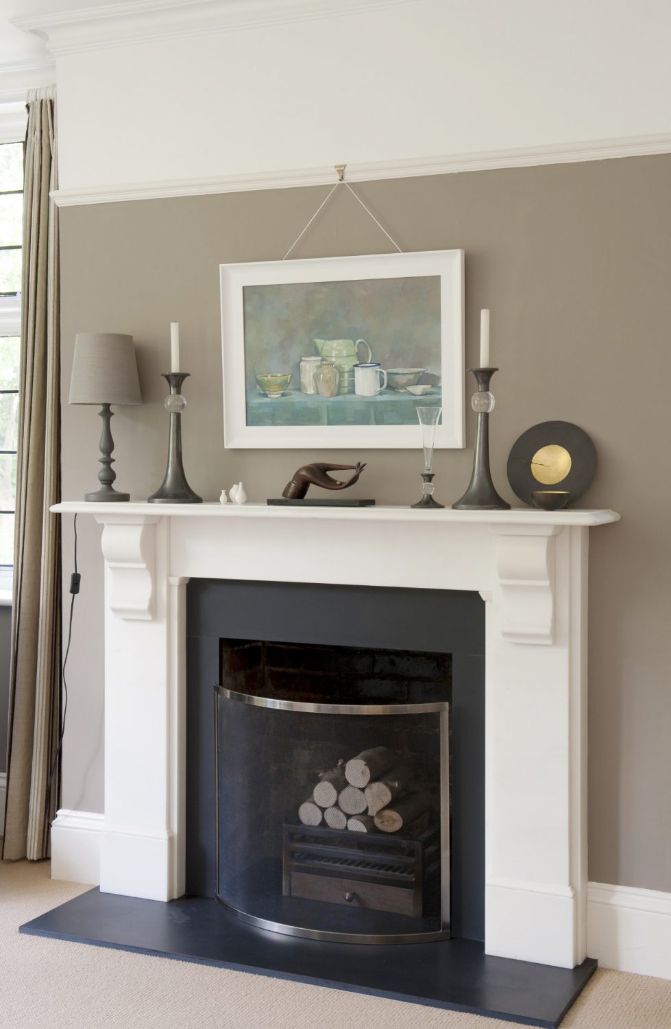 The fireplace is surrounded by neutral, restful tones