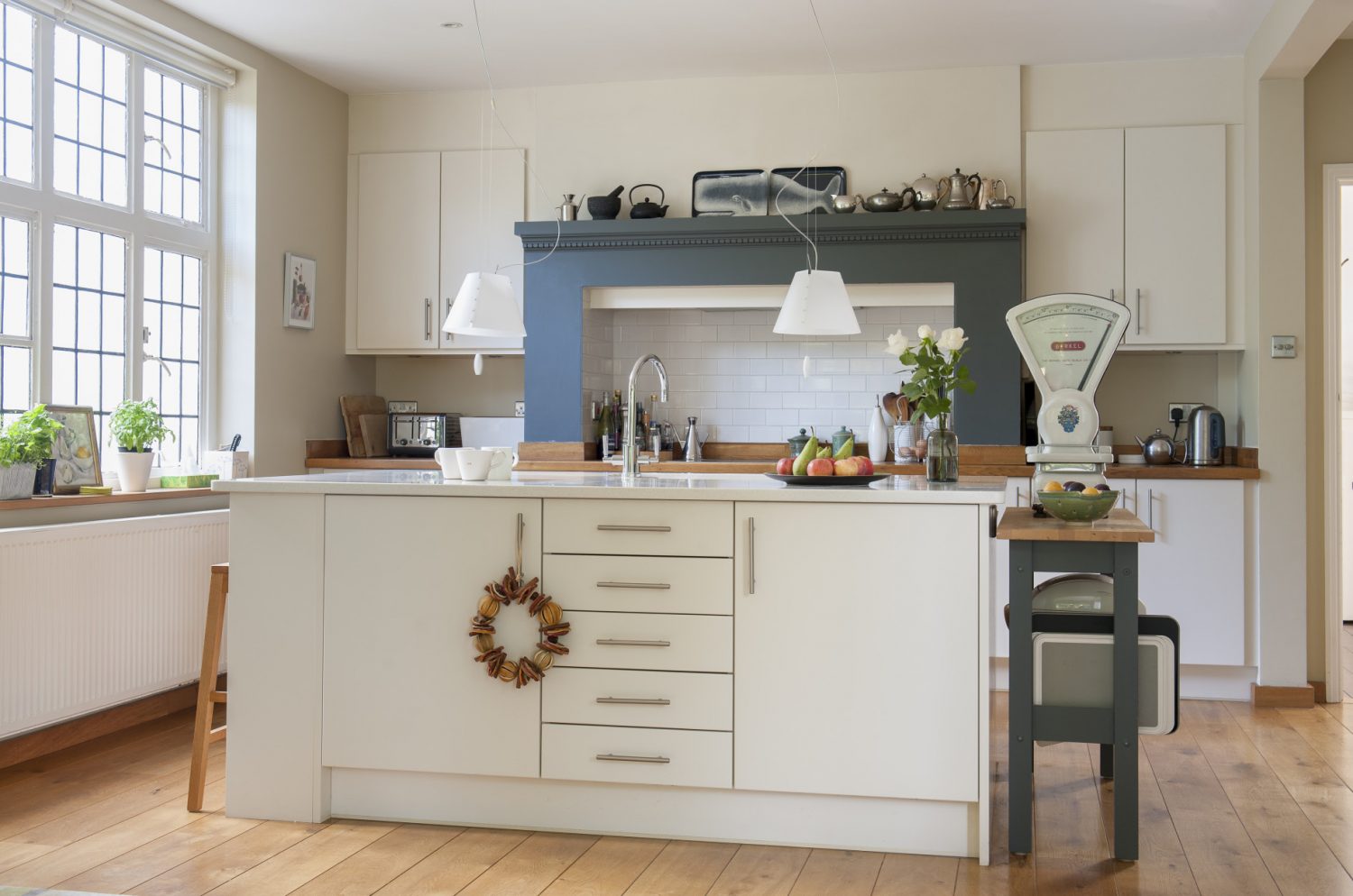 The kitchen is dominated by a free-standing unit painted in Farrow & Ball Slipper White. Featuring big and bold is a magnificent set of scales
