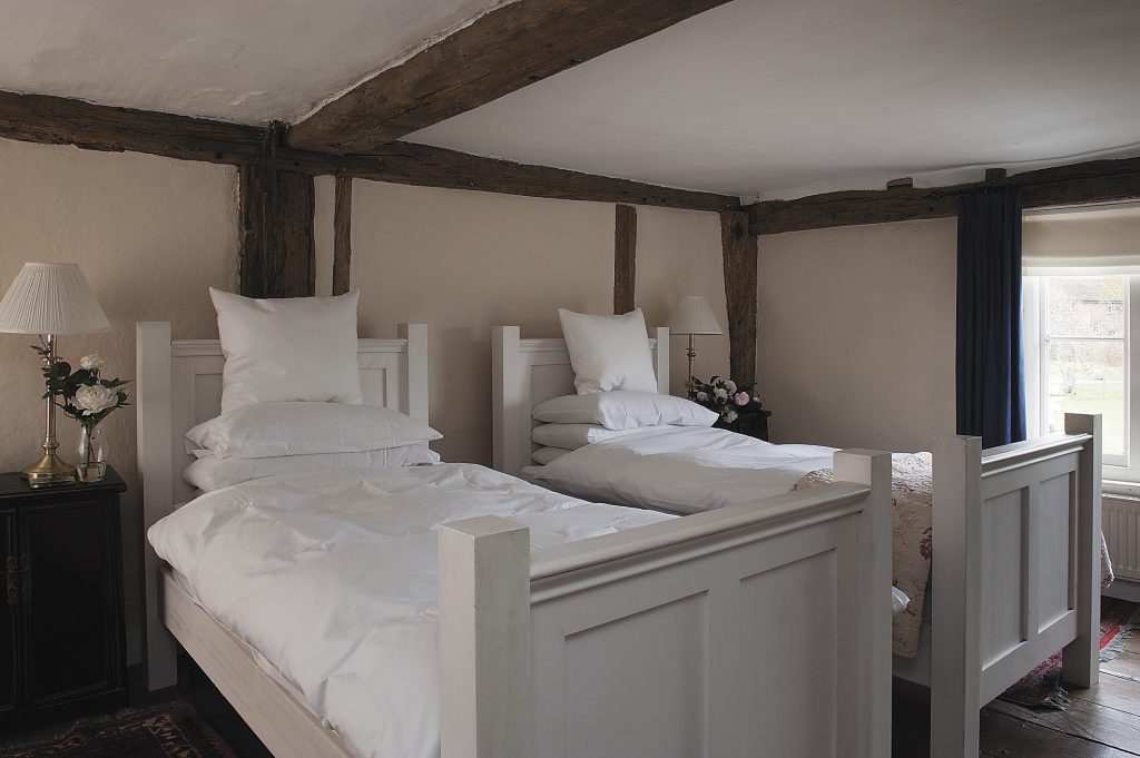 the beamed master bedroom features foot-wide oak floorboards