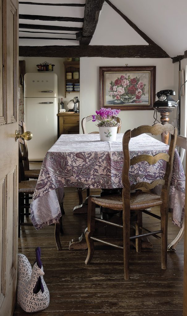 A wooden bench from an old ocean liner serves one side of the kitchen table, while delicately carved oak chairs, bought from the late lamented antiques shop in Sissinghurst, populate the remaining three sides