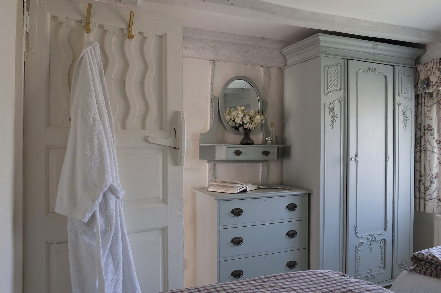 The guest bedroom is furnished with more of Dora’s furniture – a prettily carved wardrobe and chest of drawers