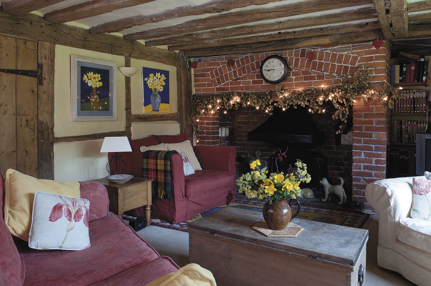 the inglenook is very much the centre of the home and is used in winter. On the wall, left, are Christine and Barry’s paintings of daffodils