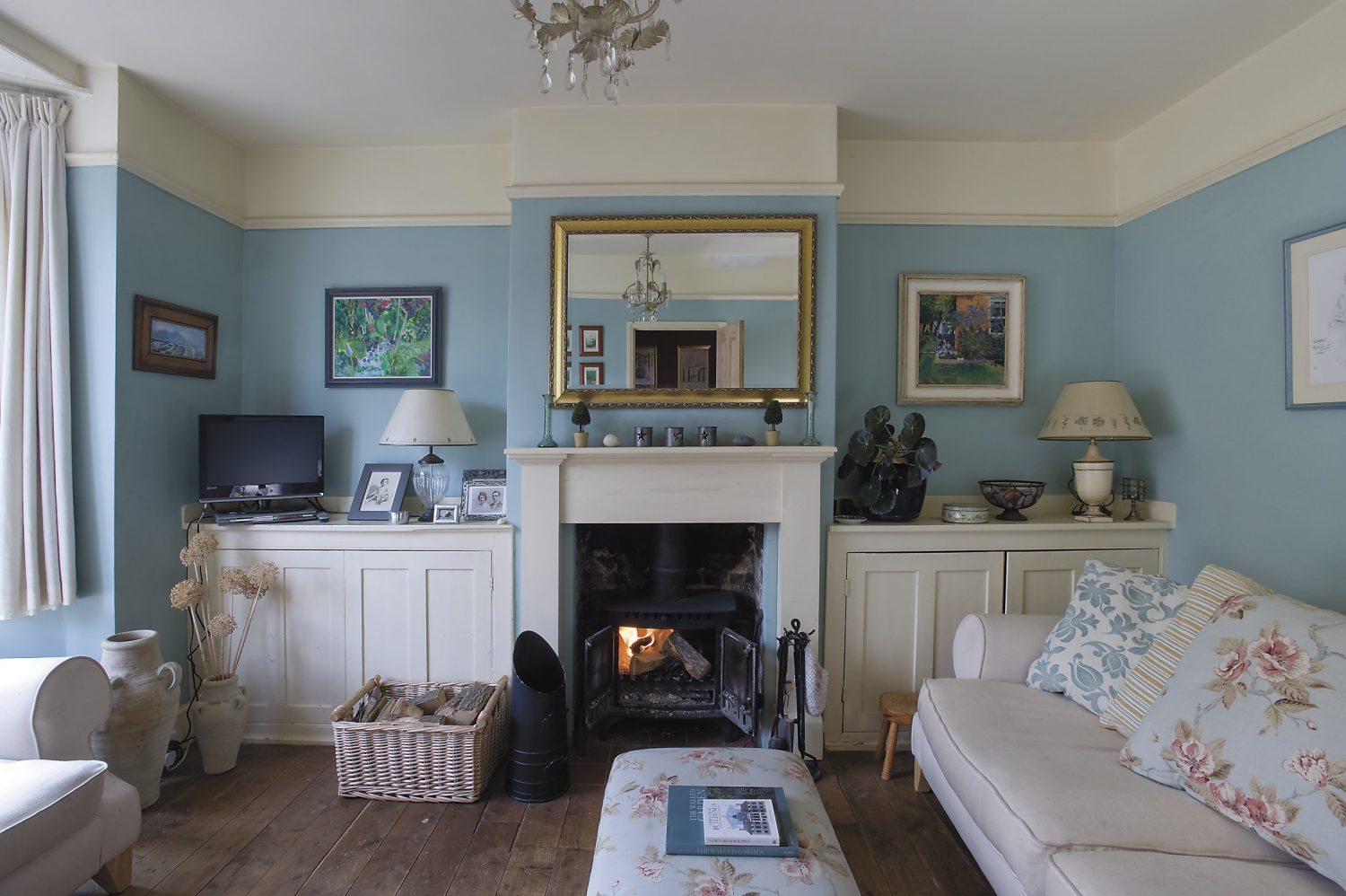 the duck-egg blue drawing room, at the front of the house, was added on in the Georgian period. The painting on the right-hand side of the fireplace is by Frittenden artist Anne-Catherine Phillips