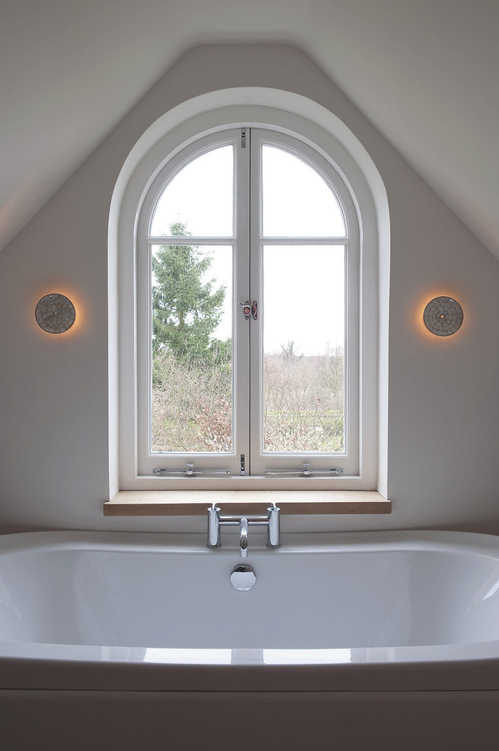 the arched window in Sally’s bathroom looks out over farmland
