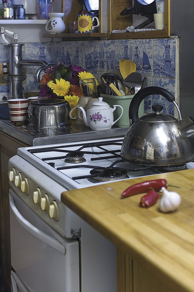 the tiny ‘galley’ kitchen is decorated with reclaimed blue and white tiles