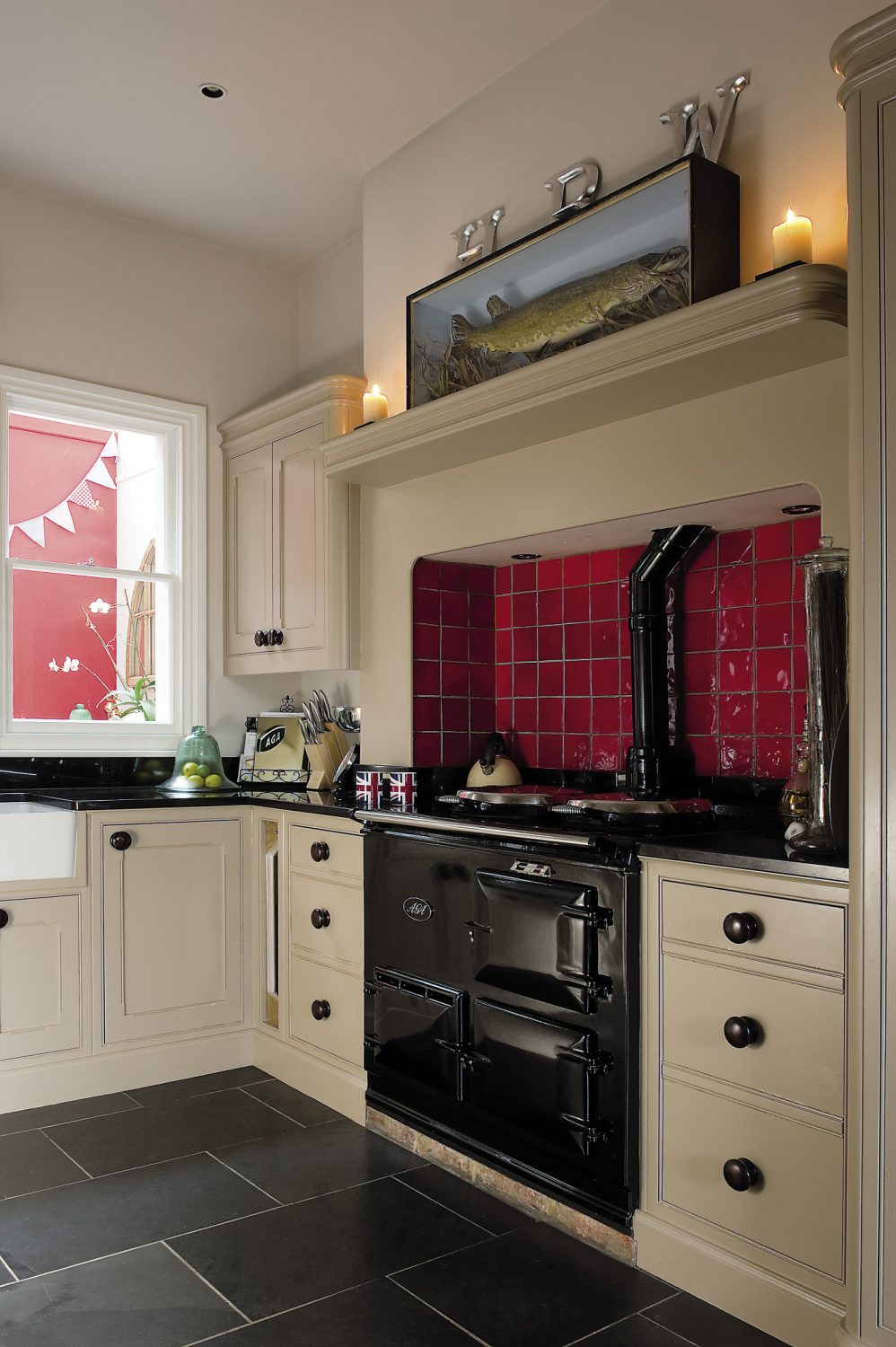 A shiny black Aga warms the room and behind it, the alcove has been covered with scarlet tiles. Sally loves to cook so it’s also a very practical and efficient space: “The Aga was non-negotiable,” she says flatly. “I’ve always cooked with one.”