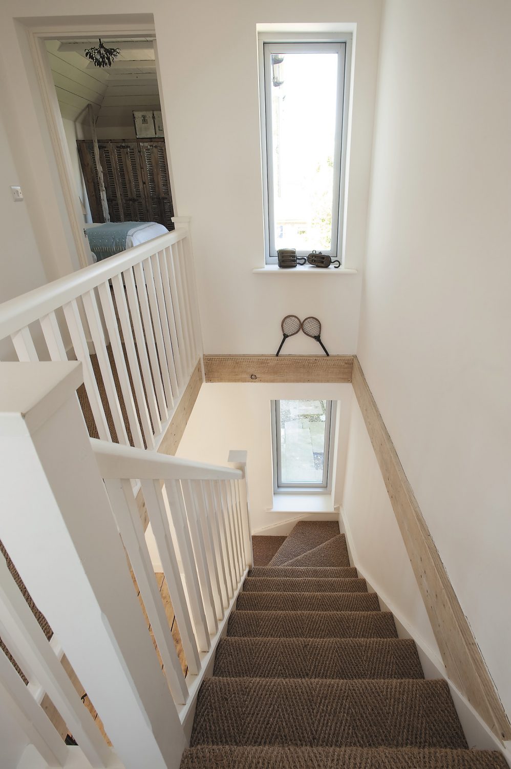 The staircase was repositioned to make the most of the light and available space; the hoists on the window ledge were probably used originally by local fishermen. The seagrass was sourced from Avalon Flooring