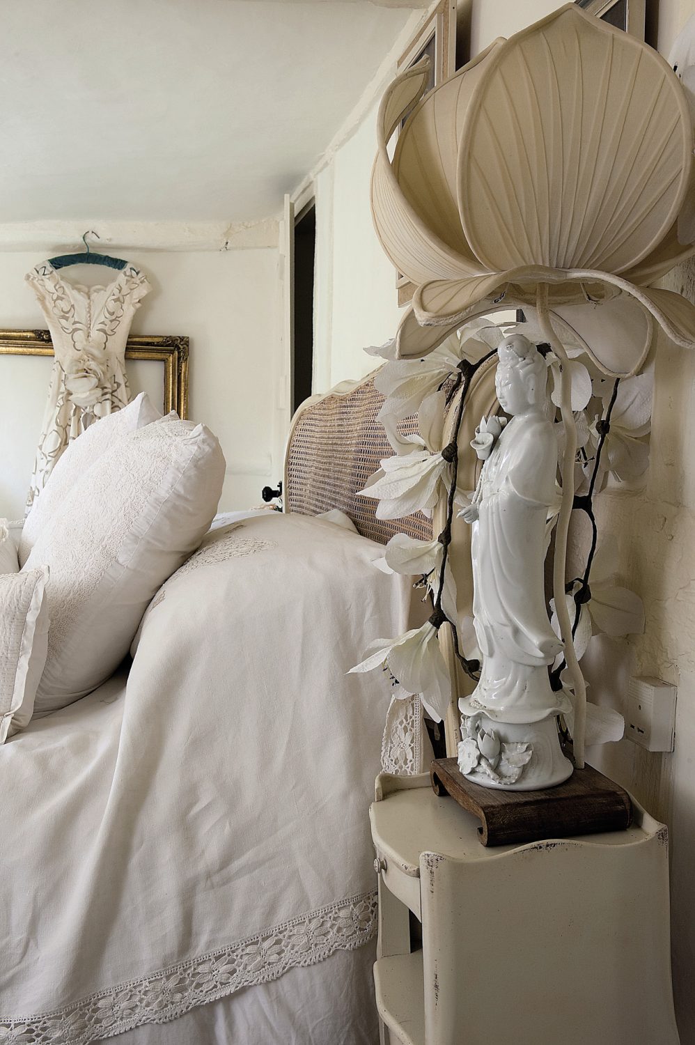 In the second bedroom again there are plenty of decorative flourishes. Ornate gilded and mirrored sconces hang above an exuberantly carved console table. Embroidered shawls cover the radiators and a vintage cutwork wedding dress is displayed on one wall