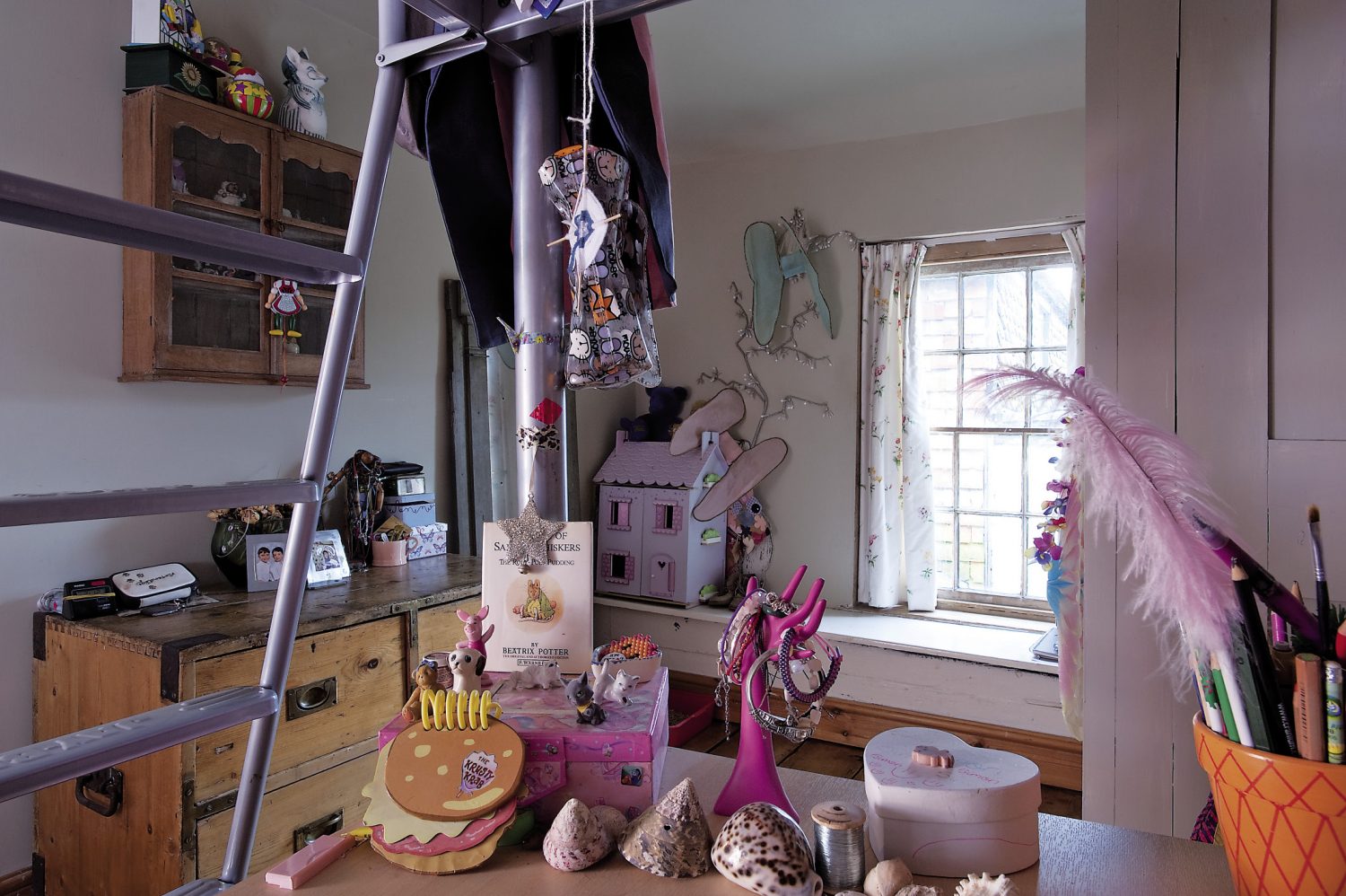 Brad and Jackie’s daughters share a room that is full of new and vintage toys. A dolls’ house stands by the window that is framed by curtains made from a Georgian style spriggy floral print. The girls’ desk already shows signs of an enthusiasm for collecting things too, with shells and found objects carefully arranged in groups