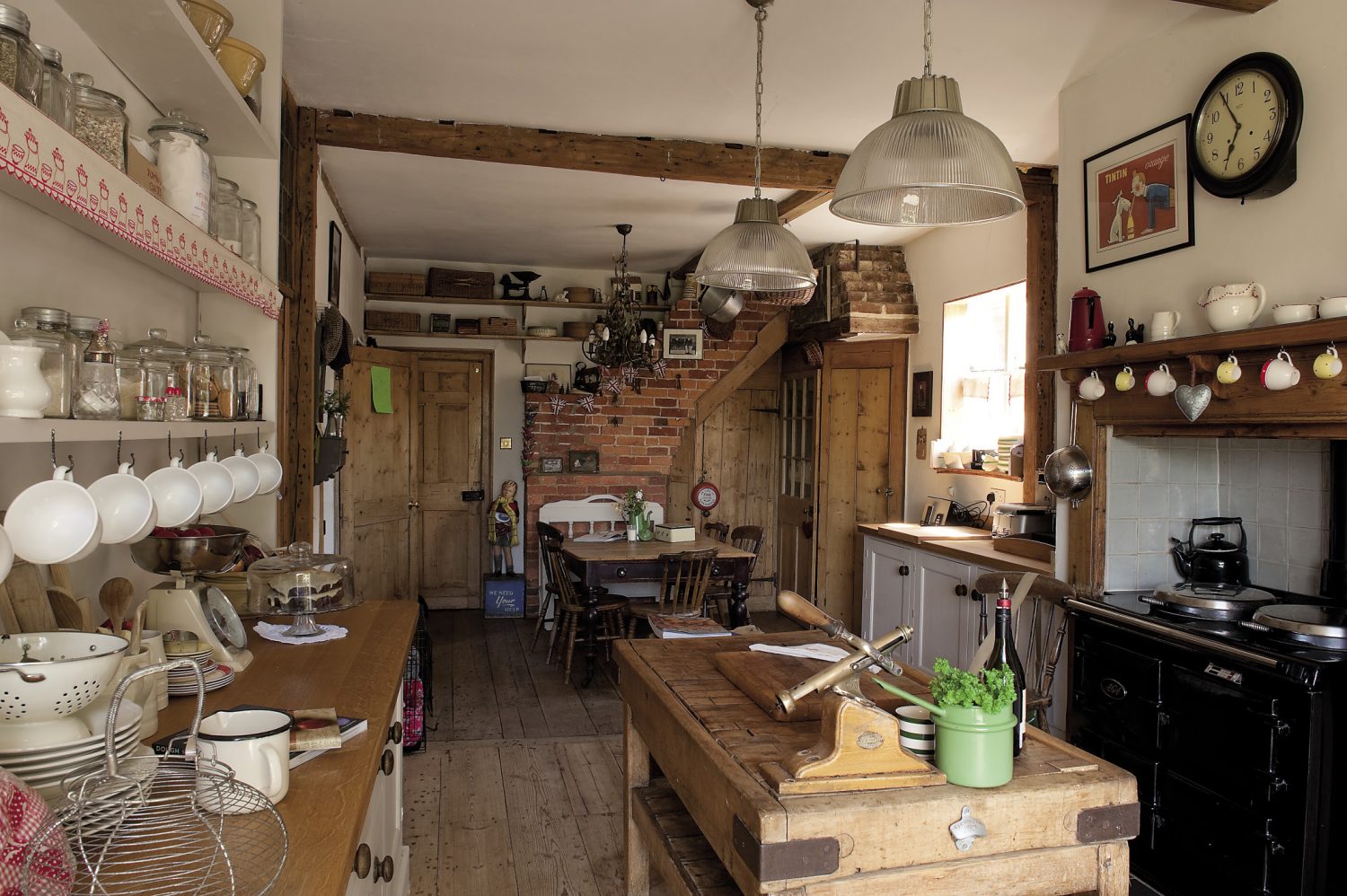 The kitchen is evidently the hub of the house. Simple in tone, it is very much a working environment, with a black enamel Aga and a deeply scored butcher’s block in the centre