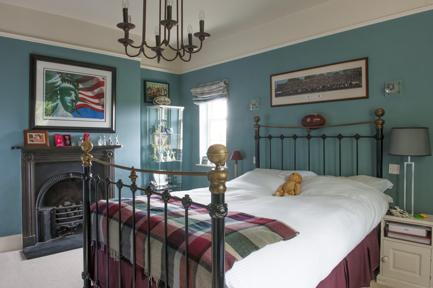 Son Charlie’s room features a brass and iron bed dressed with piqué white cotton and a plaid woollen throw