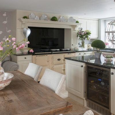 Claire’s kitchen is light and warm in tone, with ivory painted kitchen units and a pale limestone floor. The walls are painted pebble grey and there are panels of a flamboyant, Cole & Son pink flamingo wallpaper